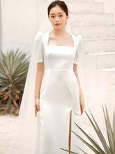 Silk dress with square neckline, puff sleeves, and front slit detail for modern elegance